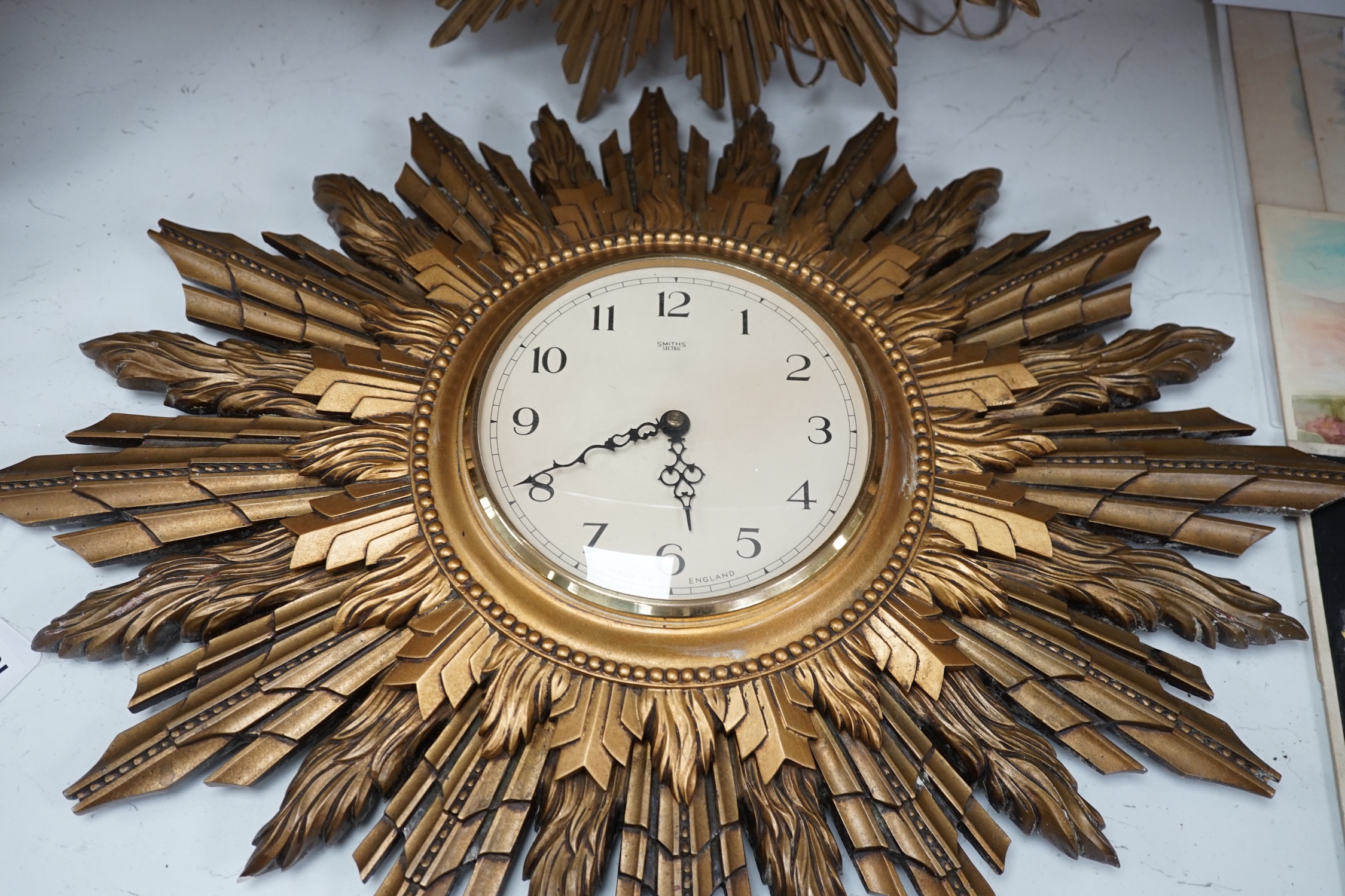 A Smiths sunburst wall clock and a similar Metamec clock, Smith clock 66cm wide